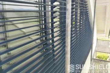 Perspectives d’un store moderne en métal, offrant une vue panoramique sur l’extérieur avec une lumière naturelle filtrée.