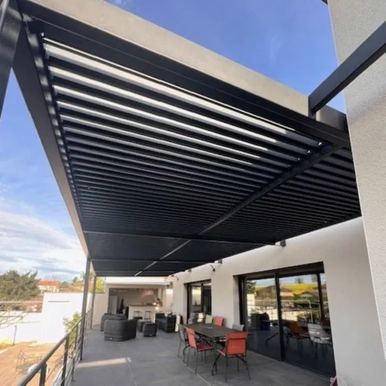 Terrasse moderne avec pergola en aluminium noir, mobilier extérieur et vue dégagée sous un ciel bleu. Idéal pour se détendre.