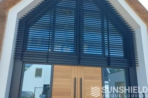 Façade moderne avec des volets bleus, encadrant une porte en bois, offrant un design élégant et contemporains.