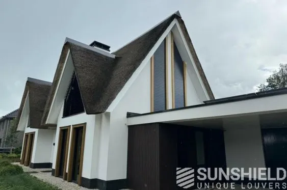 Maison moderne au design unique avec toit en chaume et facades blanches, entourée de verdure. Optimale pour le référencement SEO.