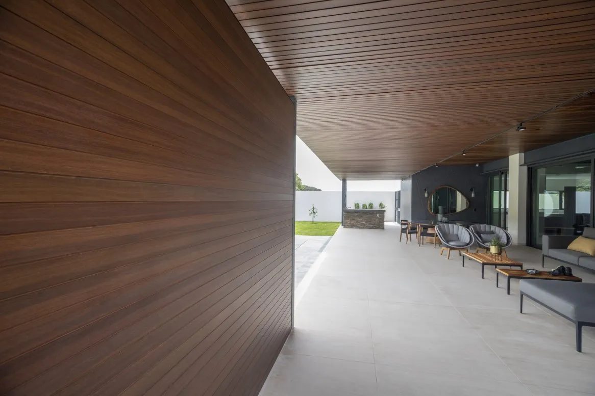 Intérieur moderne avec murs en bois et mobilier élégant, espace ouvert baigné de lumière naturelle.